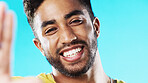 Selfie, laughing and face of a man with a smile isolated on a blue background in a studio. Happy, cheerful and portrait of a young guy taking a photo, smiling and posing for a picture on a backdrop