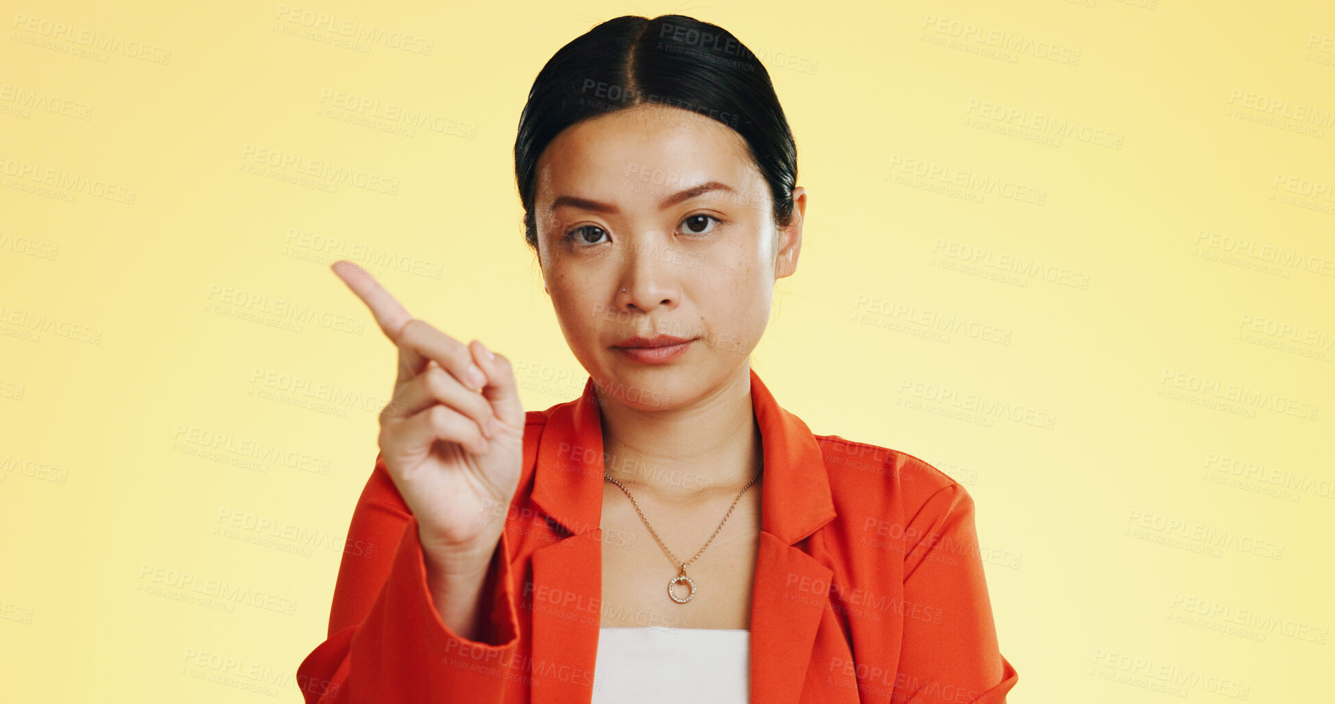 Buy stock photo Pointing, warning and portrait of Asian woman in studio with finger, serious and stop on yellow background. Emoji, disagreement and face of person with hand gesture for reject, unhappy and frustrated