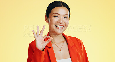 Smile, ok sign and face of Asian woman on yellow background for perfect, good job and agreement. Emoji mockup, hand gesture and portrait of happy girl in studio with success, okay symbol and yes icon