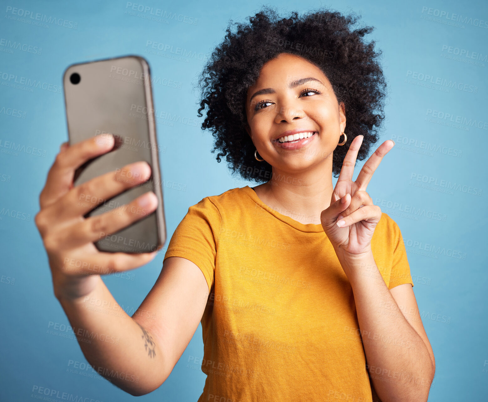 Buy stock photo Selfie, peace sign and young woman isolated on blue background for social media or content creation. Gen z, youth and african person or influencer with online profile picture and emoji in studio