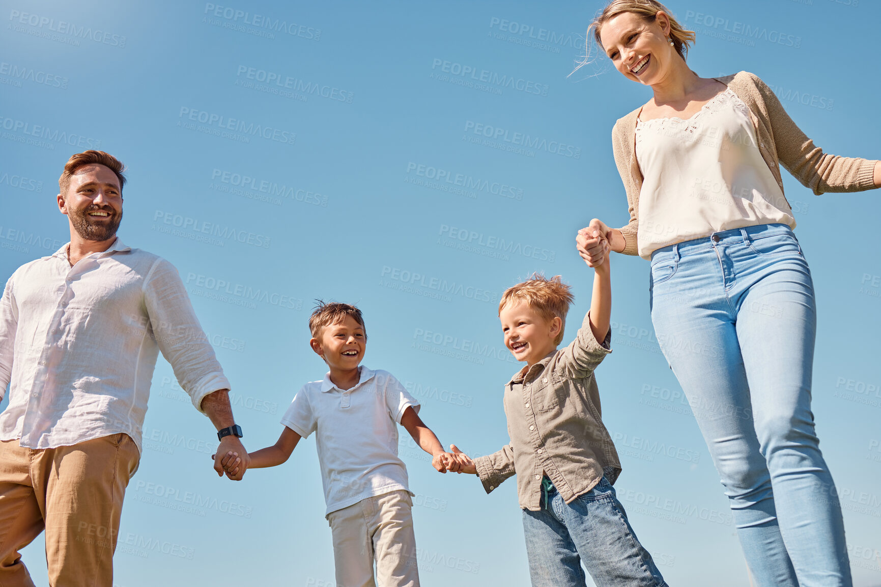Buy stock photo Family, children and sky with a mother, father and boy siblings walking hand in hand outdoor in summer. Freedom, love and kids with a brother holding hands with his parents while on a walk together