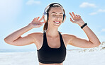 Music, headphones and woman listening during fitness outdoor, podcast or audio streaming with smile and enjoy workout. Exercise at the beach, wellness and listen to radio with energy and freedom.