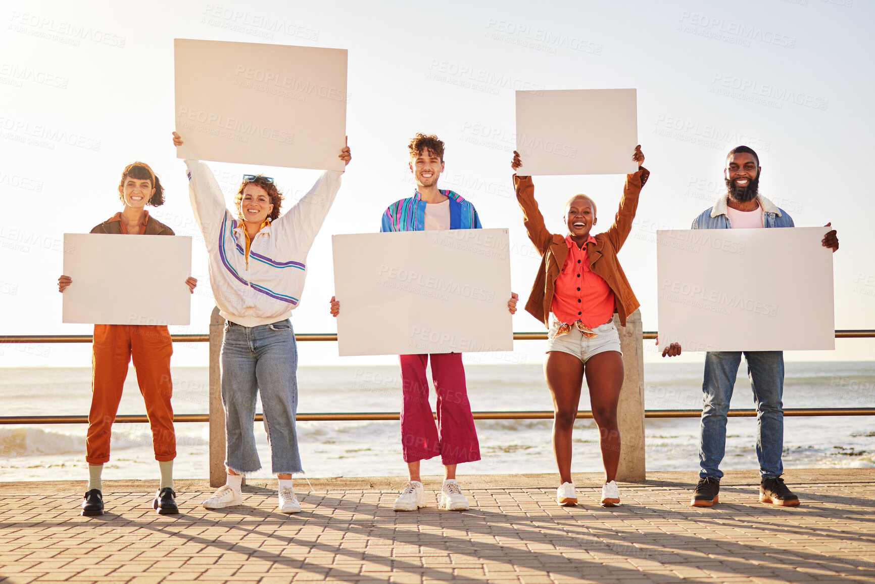 Buy stock photo Portrait, poster and diversity with friends together holding signage in protest on the promenade by the sea. Freedom, mockup and billboard with a man and woman friend group holding blank sign boards