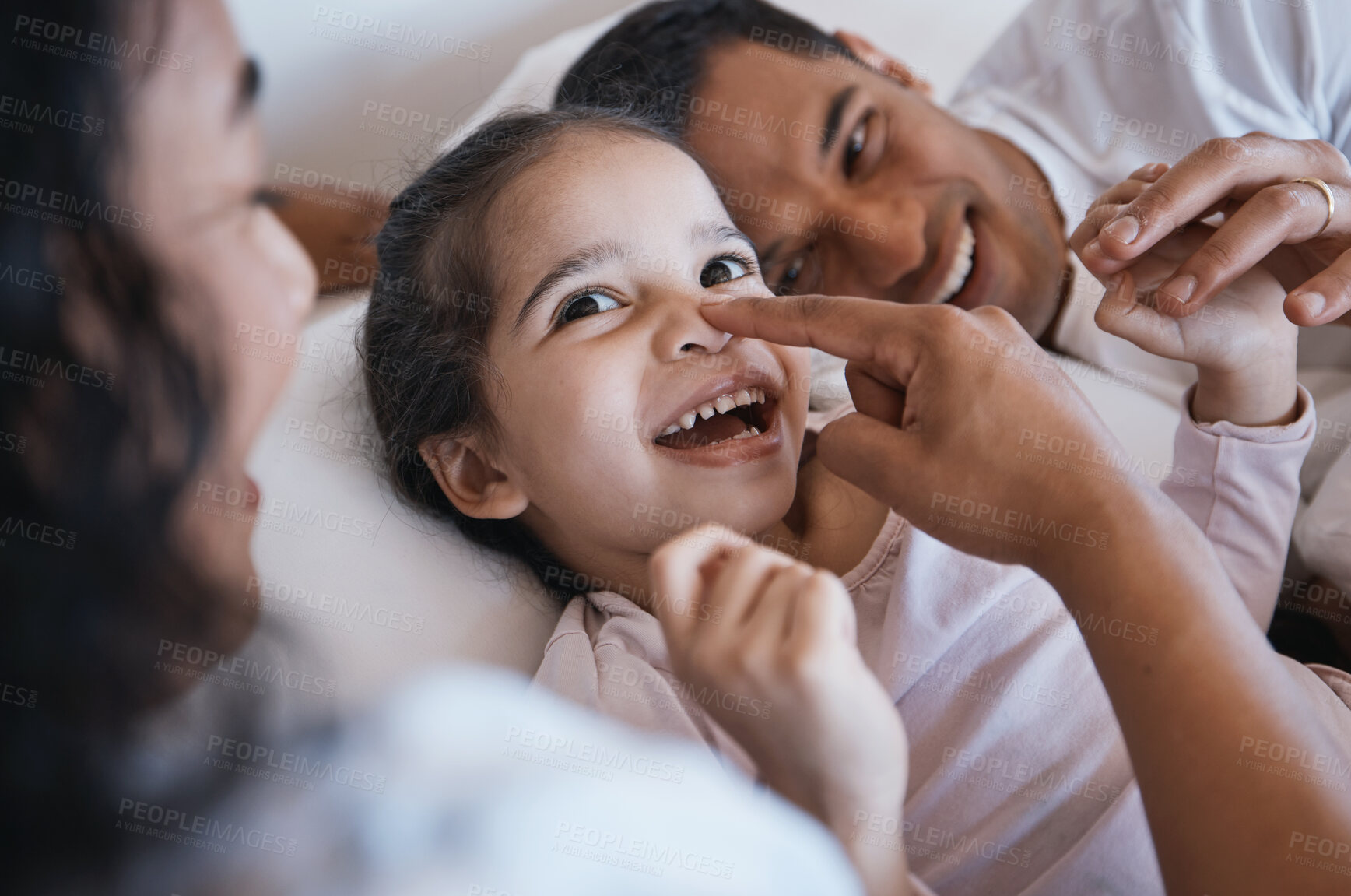 Buy stock photo Smile, love and happy family in a bed laughing, bonding and playing in their home together. Face, playful and girl child with parents in a bedroom, having fun and enjoying a weekend in their house