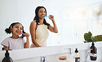 Brushing teeth, hygiene and a mother with her daughter in the bathroom of their home together for a morning routine. Kids, dental and toothbrush with a woman parent teaching her child about oral care