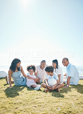 Buy stock photo Parent, children and generations are relaxing on grass in summer for quality time on holiday in mockup space. Happiness, kid and big family in outdoor for bond at resort with ball at house or ocean.