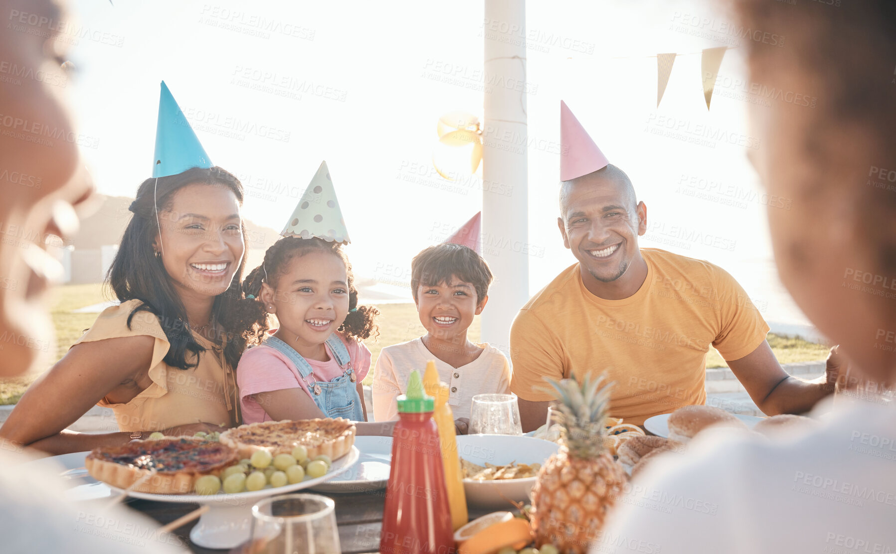 Buy stock photo Mother, father and children for birthday in park for event, celebration and party hat outdoors together. Family, social gathering and happy parents with kids at picnic with cake, presents and food