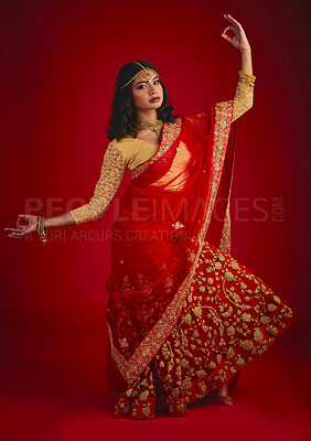 Buy stock photo Portrait, dance and Indian woman with traditional dress, celebration and motion against a red studio background. Face, female person and model with cultural clothes, jewellery and dancing with ritual