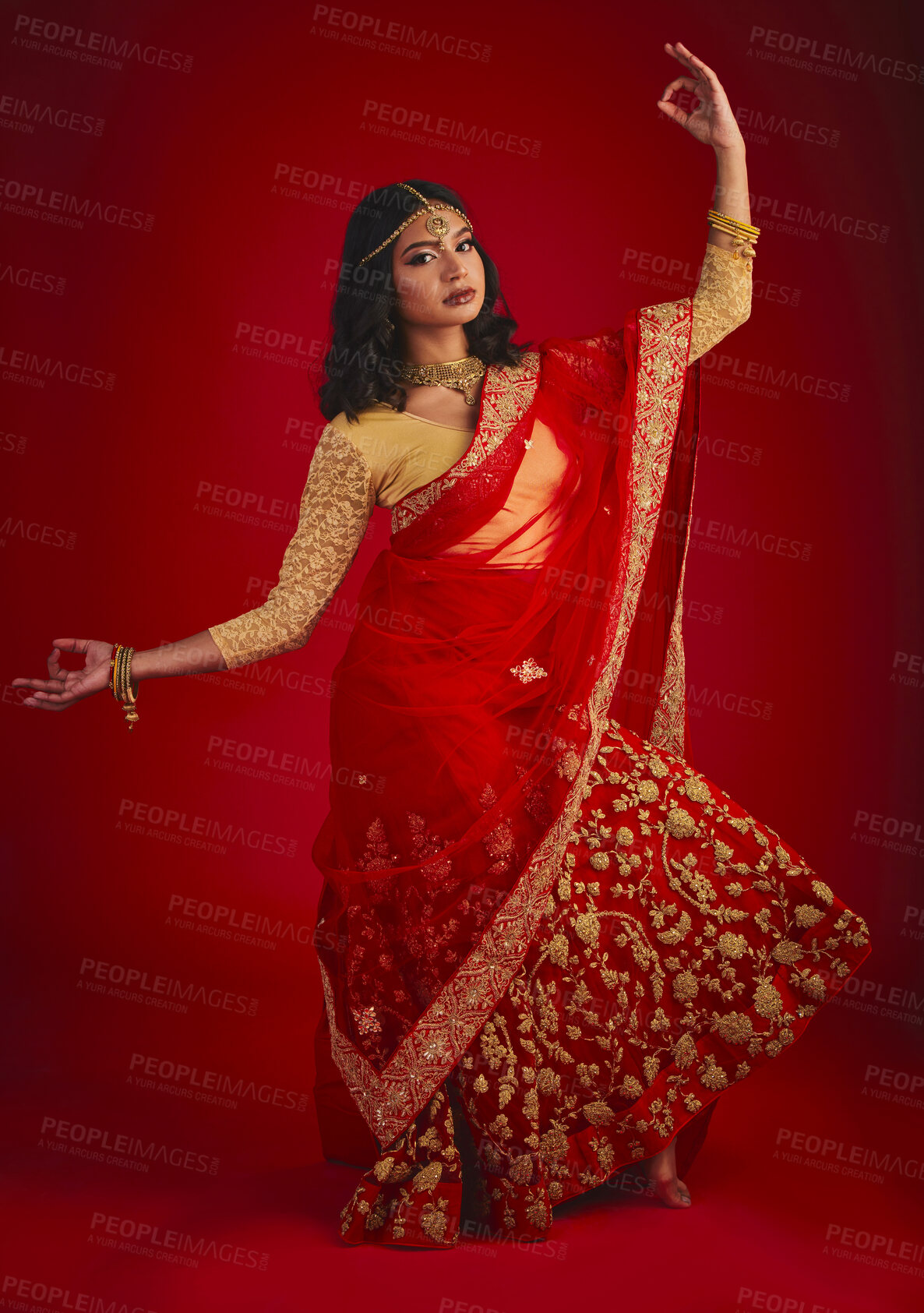 Buy stock photo Portrait, dance and Indian woman with traditional dress, celebration and motion against a red studio background. Face, female person and model with cultural clothes, jewellery and dancing with ritual
