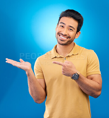 Buy stock photo Portrait, man or palm for advertising space, mockup or product placement in studio, blue background or promotion deal. Happy asian, male model and pointing to presentation, information or news review
