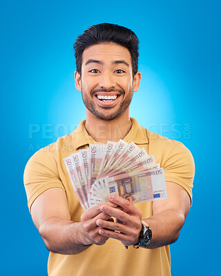 Buy stock photo Money, portrait and young man or winner with bonus, financial success and winning, cashback prize or lottery. Happy Asian person with savings, cash and investment isolated on studio blue background