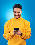 Phone, happy and young man or student for social media, college feedback or news, email and online chat. Networking, search and asian person for university info on mobile and studio, blue background
