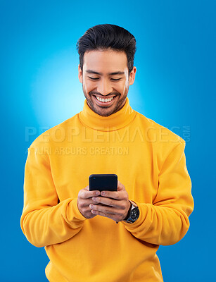 Buy stock photo Phone, happy and young man or student for social media, college feedback or news, email and online chat. Networking, search and asian person for university info on mobile and studio, blue background