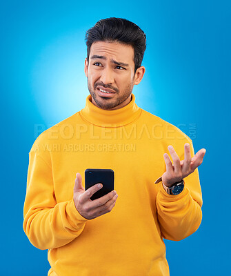 Buy stock photo Scam, error and Asian man with a smartphone, confused and internet issue against a blue studio background. Male person, guy and model with a cellphone, doubt and decision with connection problems