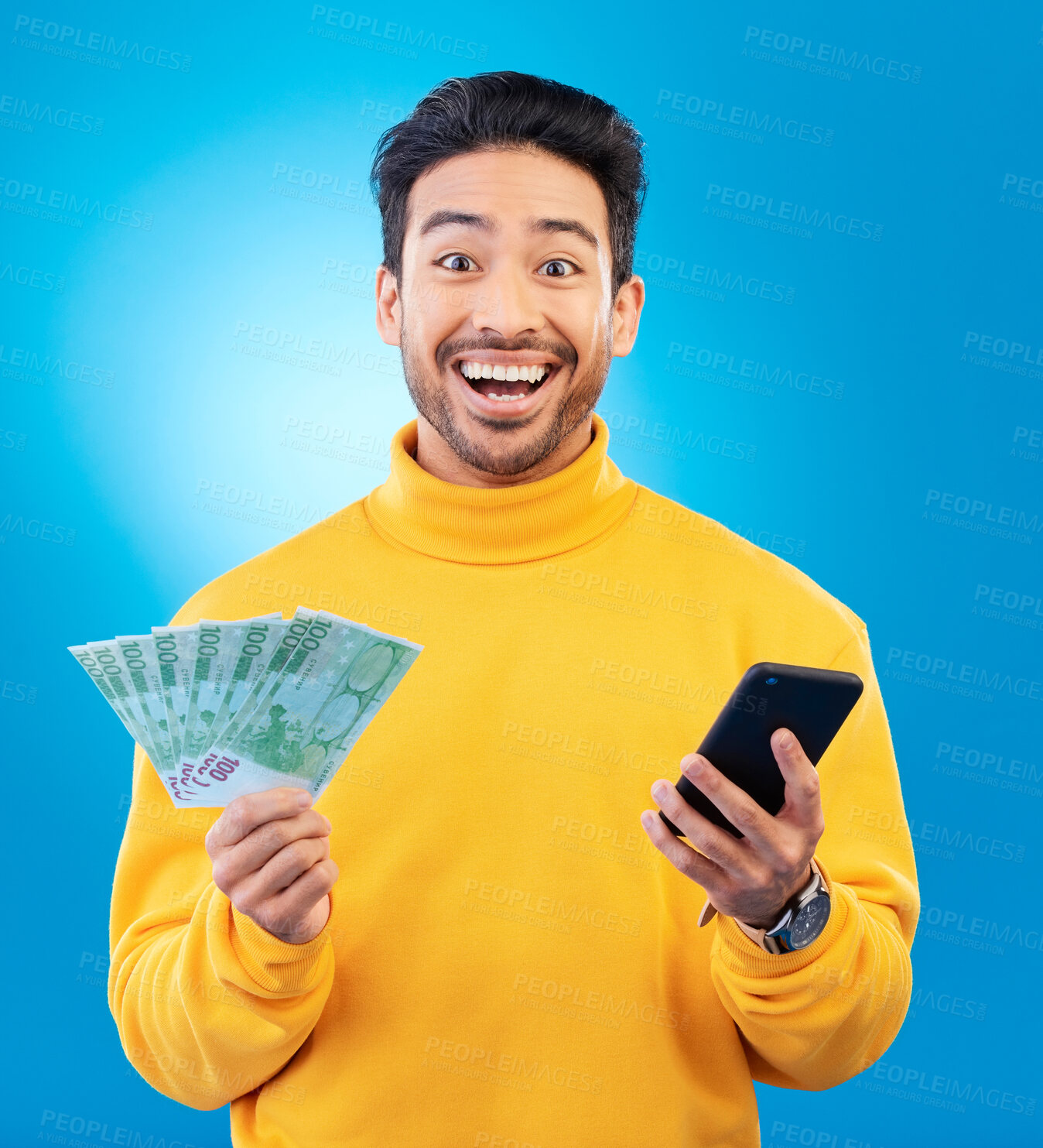 Buy stock photo Winner, money and portrait of Asian man with phone in studio for online bonus, competition and lottery. Success, finance and male person on blue background with cash for promotion, winning and deal