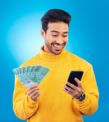 Buy stock photo Man, phone and money in studio with prize, esports gambling or happy for success by blue background. Young asian guy, student and smartphone with cash, fintech or crypto with profit, bonus or goals