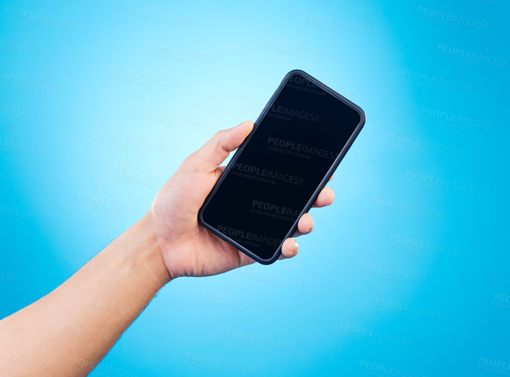 Buy stock photo Mockup, blue background and hand with phone in studio for mobile app, website and social media. Advertising, marketing and isolated person holding smartphone for promotion, branding and information