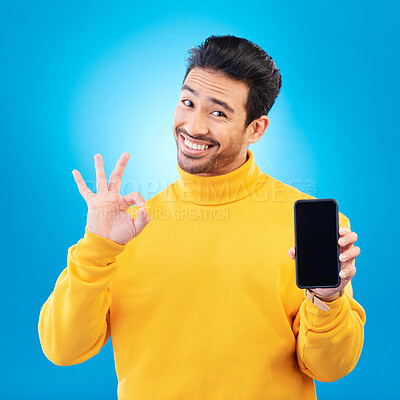 Buy stock photo Advertising, portrait of a man with smartphone and okay or like sign in blue background happy for social networking. Online app or technology, marketing or branding and male person with cellphone