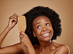 Black woman, hairstyle and smile for brush in studio, brown background and treatment for curly texture. Natural beauty, confidence and happy young african female model comb clean or healthy afro hair