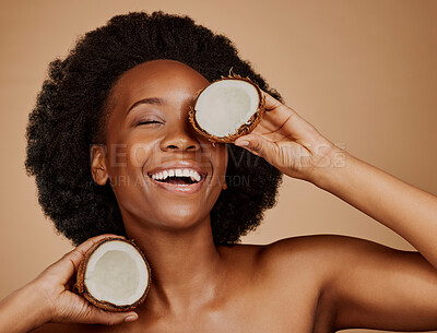 Buy stock photo Happy, glow and black woman with coconut for skincare, dermatology treatment and health. Laughing, wellness and an African model with a smile for food for hair care isolated on a studio background