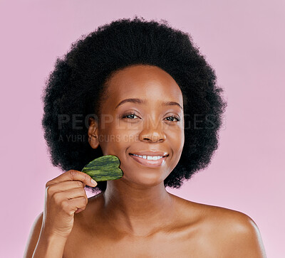 Buy stock photo Gua sha, facial massage and black woman with natural beauty, face care and skin glow on pink background. Female model, jade cosmetic tools and dermatology with afro hair and skincare in studio