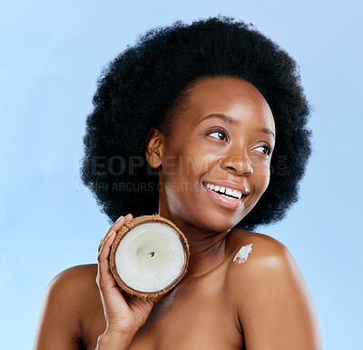 Buy stock photo Beauty, skin and coconut with a model black woman in studio on a blue background for natural treatment. Thinking, skincare and cosmetics with a happy young female person holding fruit for oil