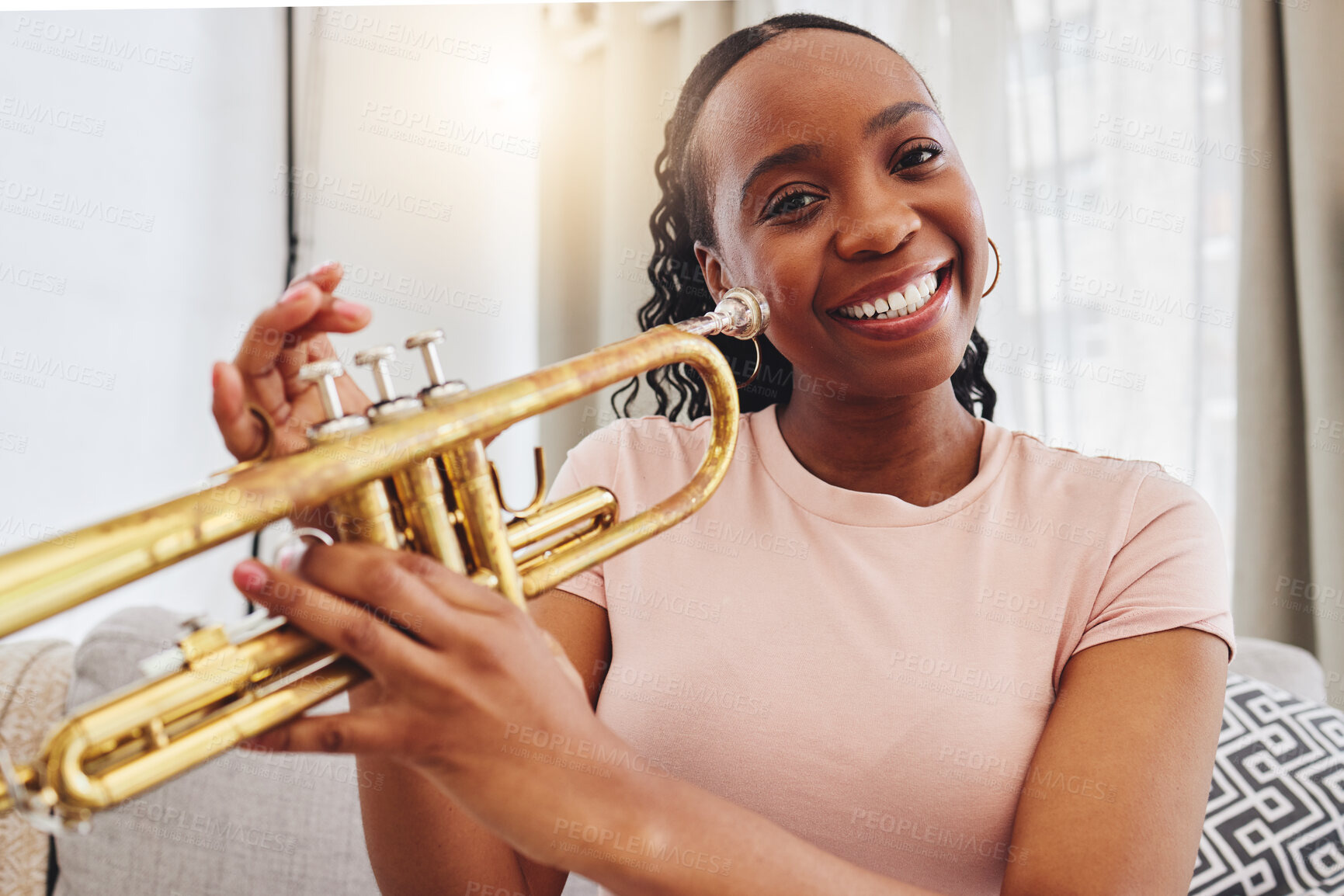 Buy stock photo Music, portrait and woman in home with trumpet, smile and band practice for orchestra concert in living room. Art, creativity and jazz culture, happy African musician on sofa with musical instrument.