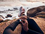 Relax, check and smart watch with hand of woman on rock for running, fitness tracker and heart rate. Workout, exercise and goal with closeup of female runner at beach for monitor, goals and time