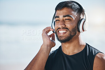 Buy stock photo Happy, beach and a man with music for fitness, running motivation and ideas in nature. Smile, wellness and an athlete listening or streaming a podcast while training or exercise vision at the sea