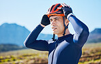 Mountain, helmet and man cycling in a marathon, fitness training or competition or sports adventure with blue sky. Gear, athlete and safety in outdoor cycle, bike ride or exercise in nature or park