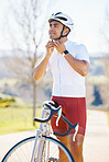 Bicycle, helmet and man cycling in a competition, fitness training or marathon or sports adventure with blue sky. Gear, athlete and safety in outdoor cycle, bike ride or exercise in nature or park