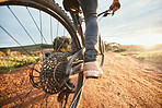 Feet, cycling and a man on a bike and dirt road for fitness, morning cardio or adventure in nature. Sports, tire and a person on a bicycle for a race, competition or exercise in the countryside