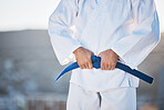 Karate, exercise and fighting with a sports man in gi, training in the city on a blurred background. Fitness, discipline or strong with a male athlete during a self defense workout for health closeup