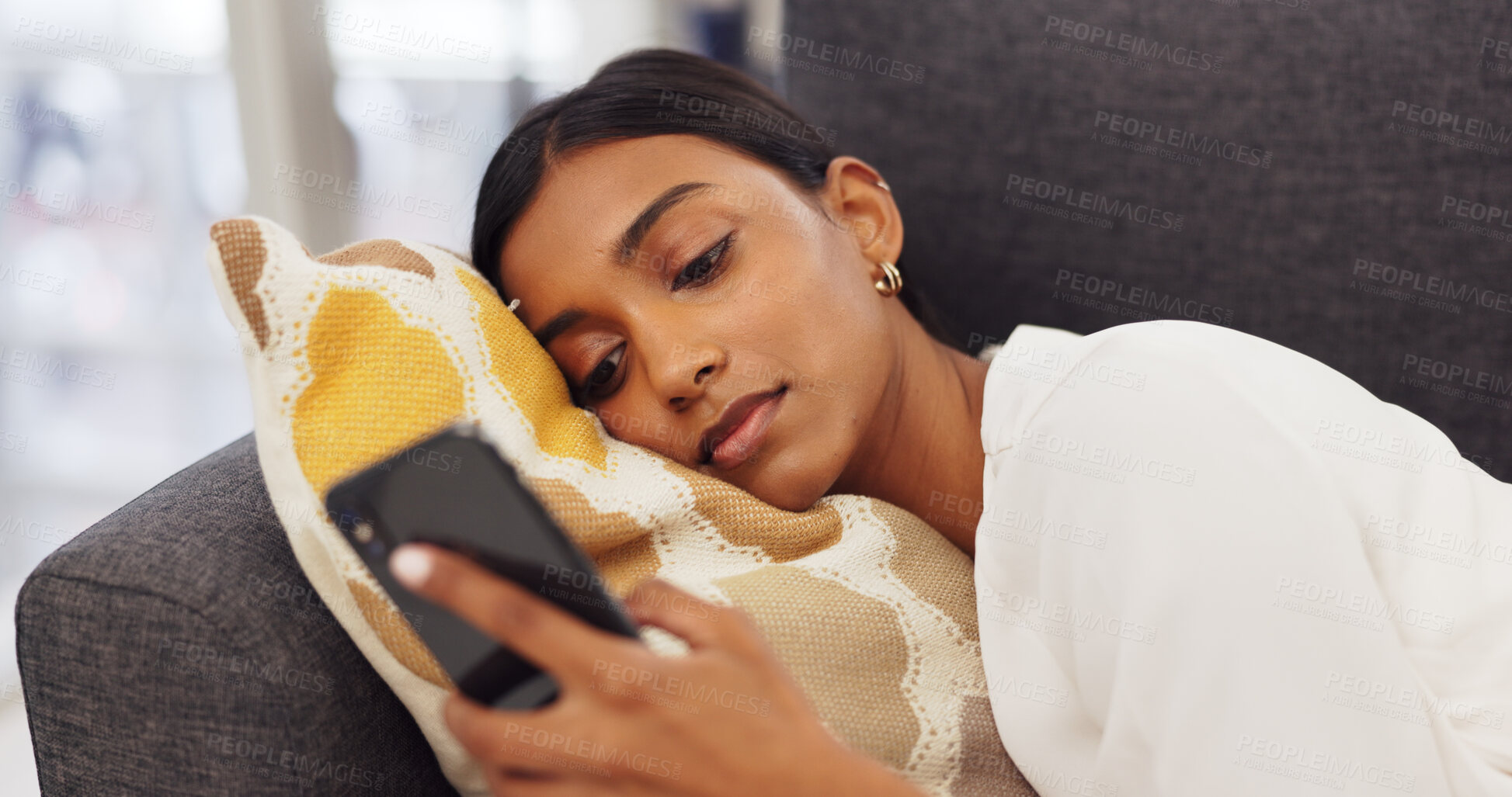 Buy stock photo Online, relax and Indian woman on sofa with phone for website, internet and social media at home. Communication, connection and person laying on couch in living room on smartphone for mobile app