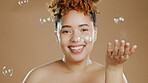Skincare, cosmetics and bubbles, black woman in studio with smile on face and natural makeup isolated on studio background. Beauty, aesthetic and African model with cleaning facial at dermatology spa