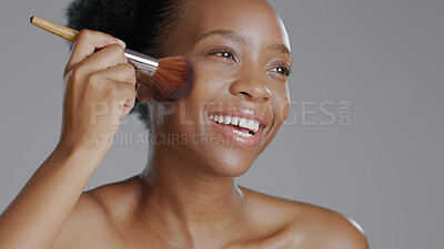 Buy stock photo Black woman, brush for makeup and beauty with face, natural cosmetics and apply foundation on grey background. Skin, glow and cosmetology with tools, powder with facial and model smile in studio