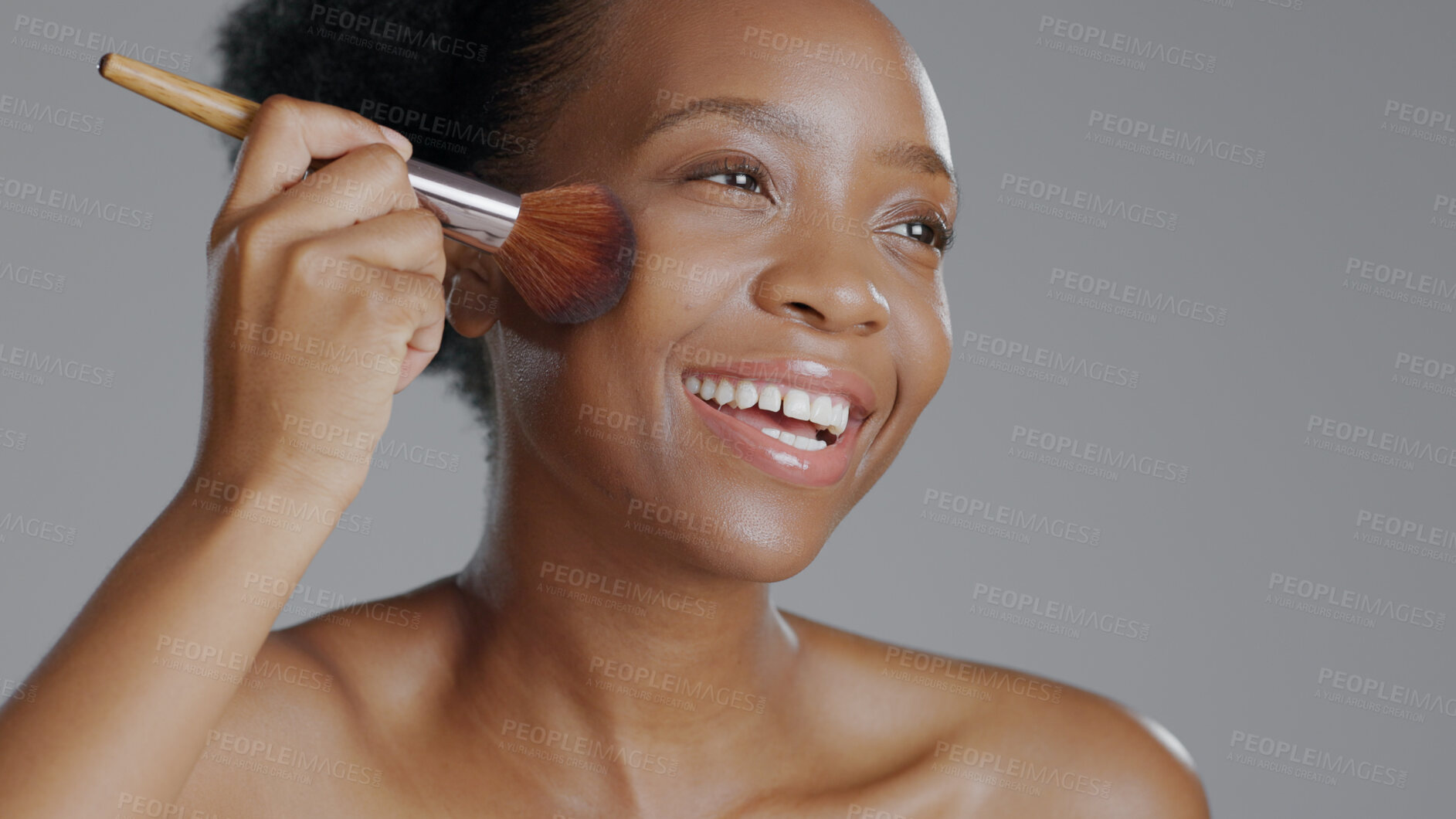 Buy stock photo Black woman, brush for makeup and beauty with face, natural cosmetics and apply foundation on grey background. Skin, glow and cosmetology with tools, powder with facial and model smile in studio