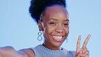 Face, selfie and black woman with peace sign and kiss in studio isolated on blue background. Laughing, smile or beauty portrait of happy female model with v hand emoji, air kissing or taking pictures