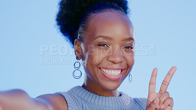 Buy stock photo Happy, selfie and black woman with peace sign with smile isolated in a studio blue background as emoji. Happiness, cool or portrait of person with v hand gesture for social media picture online