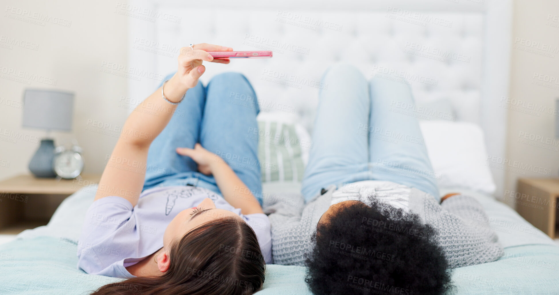 Buy stock photo  for bonding, resting and chilling together. Cellphone, happy and young lgbtq women taking a picture for memory in the bedroom of modern apartment.