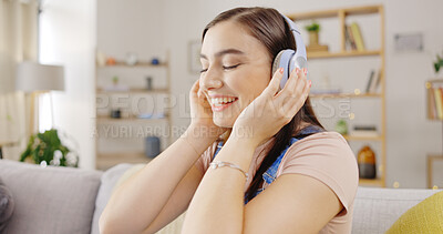 Buy stock photo Smile, music and a woman on a sofa in the living room of her home to relax while streaming audio. Freedom, wellness and a happy young person listening to a radio subscription service in her apartment