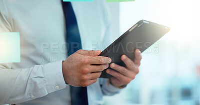 Buy stock photo Market Research Analyst creating a strategy to boost sales and profits for the business in the office. Sales director on a tablet making a plan and checking goals and targets on a board in the office