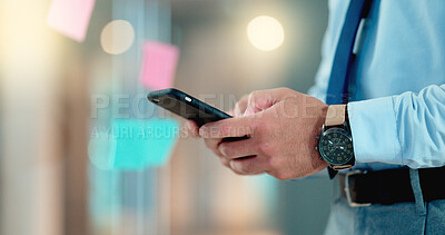 Businessman texting an email on his phone in a modern office. Corporate worker schedule a meeting with an instant business text message app. Closeup of trendy man sharing ideas online on social media
