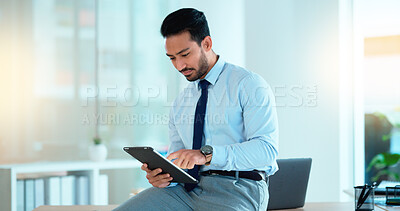 Buy stock photo Successful young business man laughing while browsing on a tablet in the office. Portrait of a confident male corporate professional feeling positive after completing a deal or finishing a task