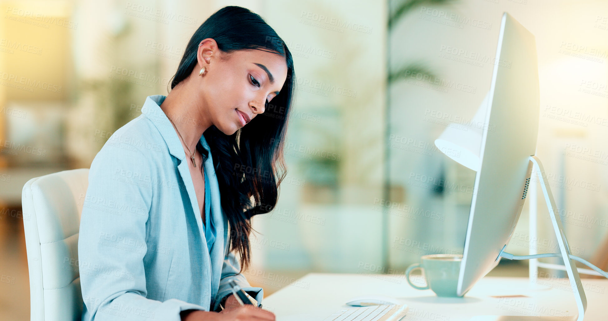 Buy stock photo Businesswoman typing out financial reports while working on a computer in her office. Female accountant managing finances and doing bookkeeping using software to compile data and writing notes