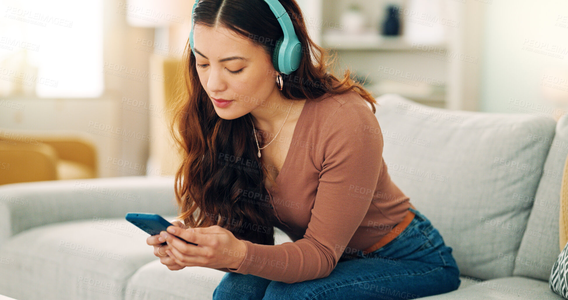 Buy stock photo Woman, phone or music headphones on relax sofa in house or Singaporean home living room. Smile,enjoy or happy student with mobile technology for podcast, dance radio or audio playlist app in lockdown