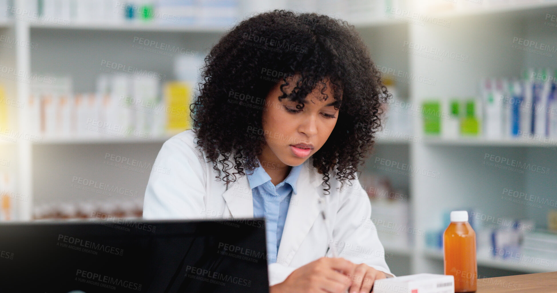 Buy stock photo Young and focused pharmacist use her computer to do stock taking and dispense medicine in a pharmacy or drugstore. Female health professional or chemist filling out prescription medication documents