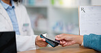 Closeup customer hands using ebanking credit card to pay on contactless nfc machine to collect prescription medication from pharmacist. Man tapping or scanning electronic device for pharmacy medicine