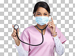 PNG cropped portrait of an attractive young female healthcare worker wearing a mask and holding up a stethoscope in studio against a grey background