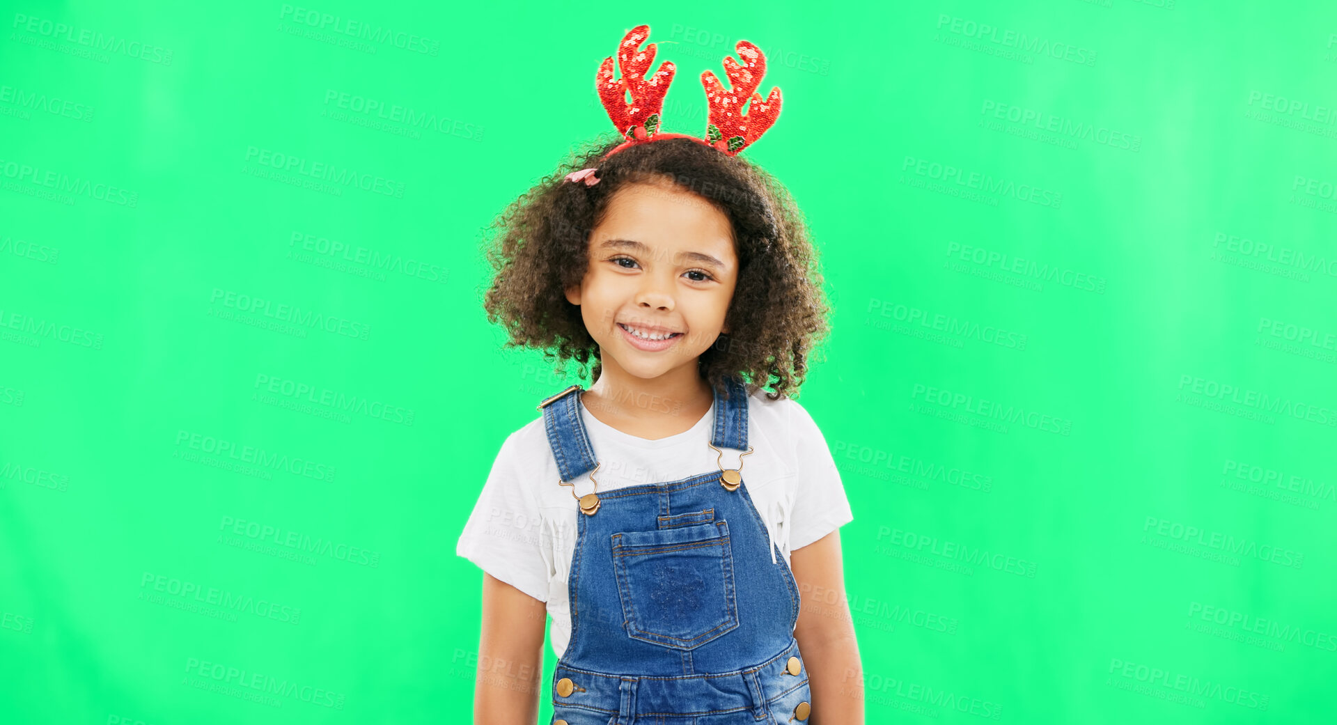 Buy stock photo Children, christmas and a girl on a green screen background in studio wearing a reindeer antlers headband. Kids, portrait or festive with an adorable little female child feeling happy in the holidays